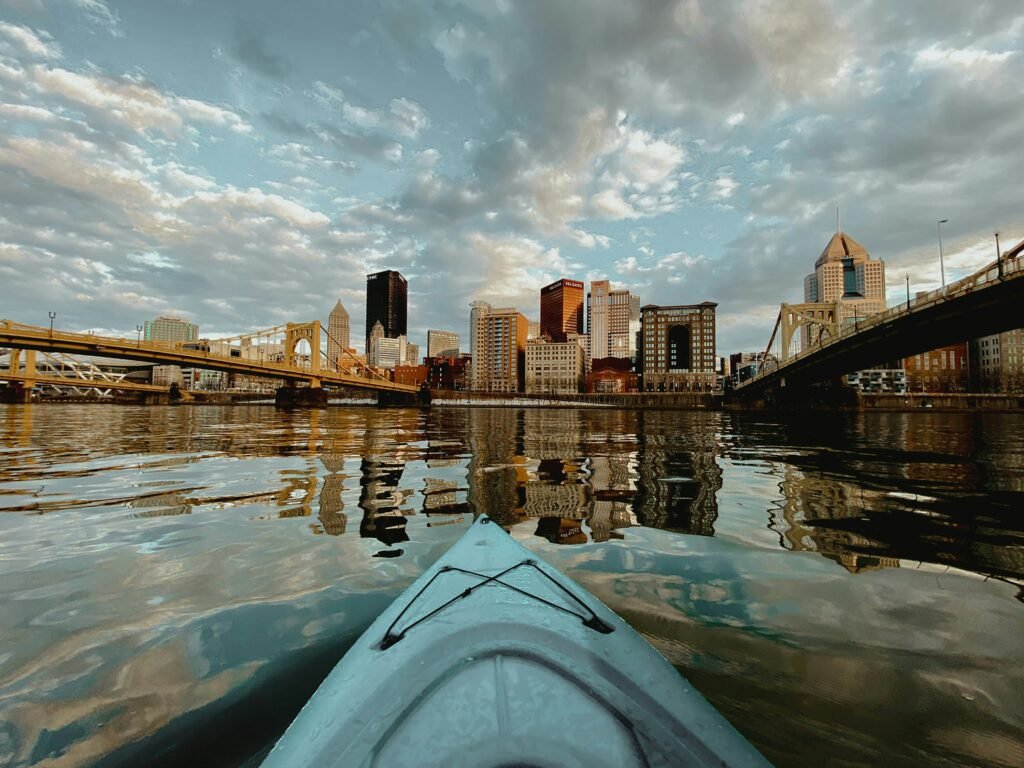 A group kayaking trip on Pittsburgh’s rivers with the downtown skyline in view, showcasing one of the top outdoor group activities in Pittsburgh.