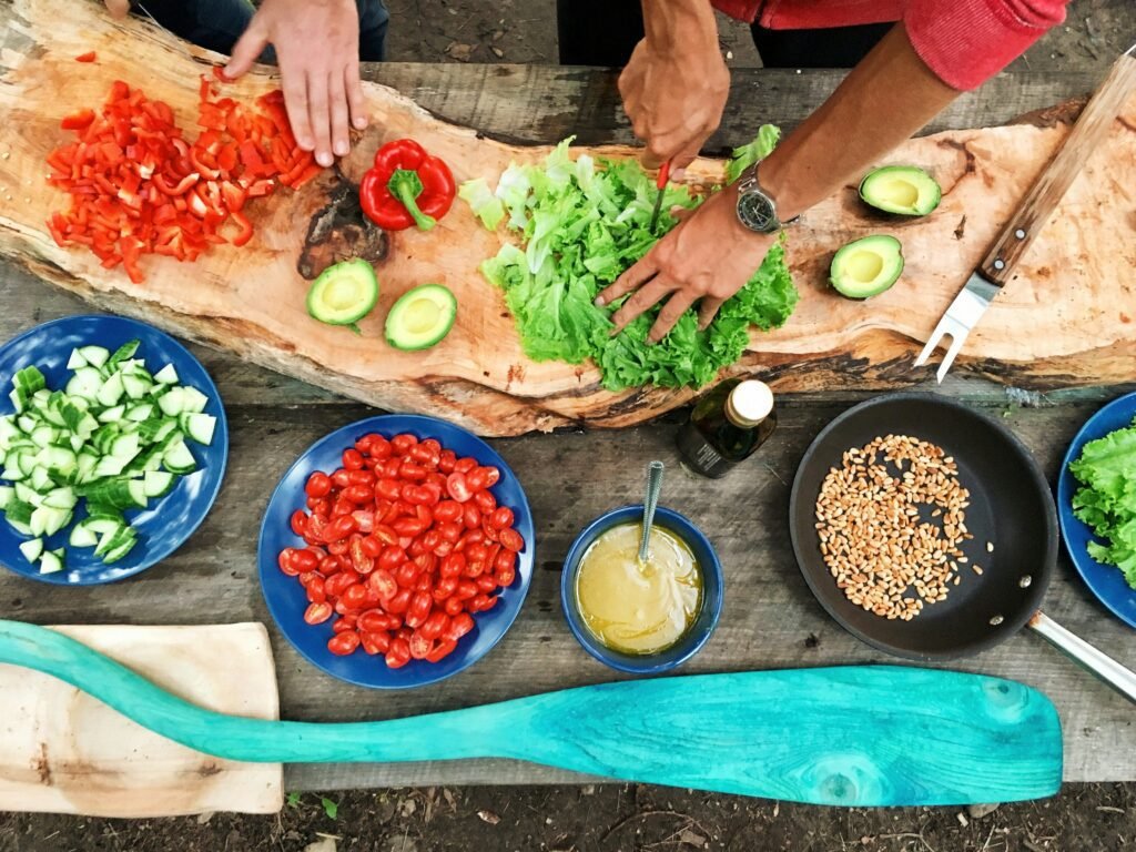 Hands chopping vegetables and preparing fresh ingredients for a cooking class, an example of a group activity in Pittsburgh.